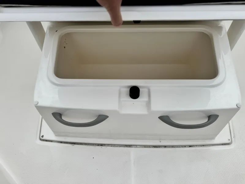 Slide: The Image of 2022 Bayliner Trophy T22CC storage compartment with open lid and handles. - 11