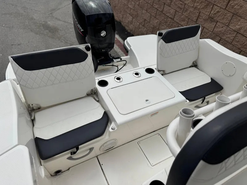 Slide: The Image of 2022 Bayliner Trophy T22CC boat seating area with storage and motor. - 12