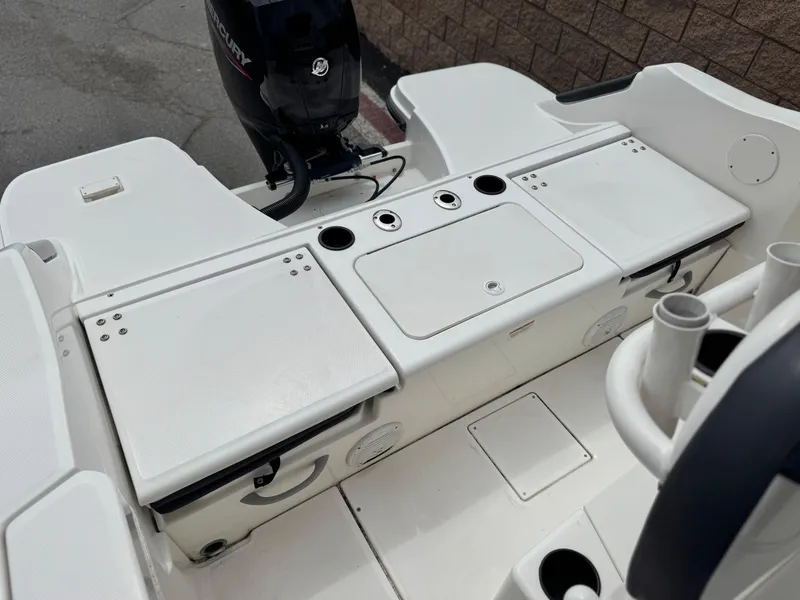 Slide: The Image of 2022 Bayliner Trophy T22CC boat interior with storage compartments and motor. - 13