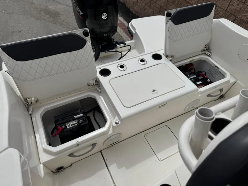 Slide: The Image of 2022 Bayliner Trophy T22CC boat with open storage compartments and visible battery setup. - 14