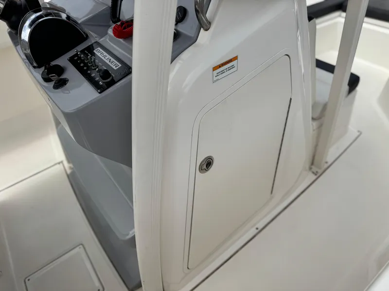 Slide: The Image of 2022 Bayliner Trophy T22CC boat console with control panel and storage compartment. - 27