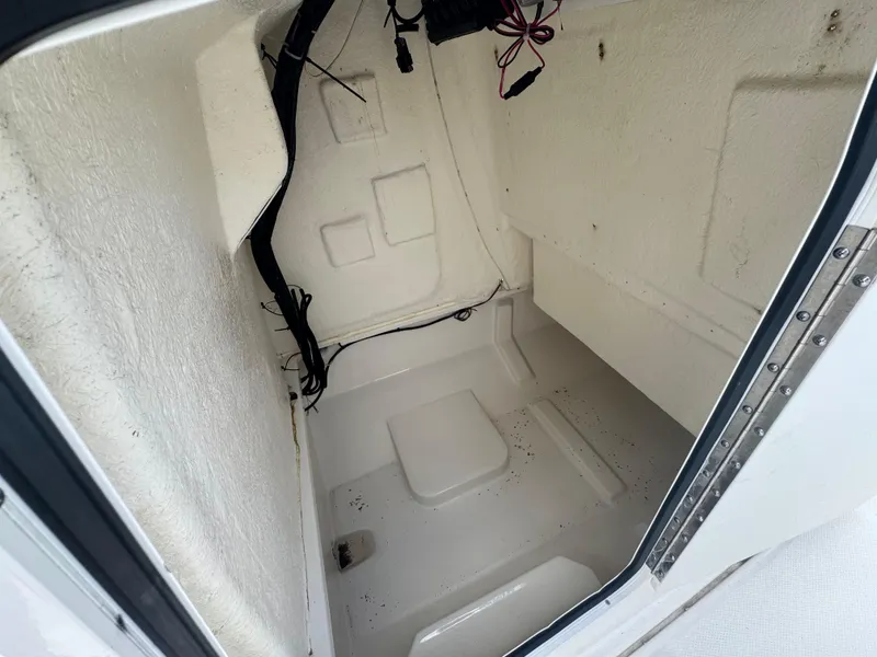 Slide: The Image of 2022 Bayliner Trophy T22CC storage compartment interior, featuring clean white fiberglass finish. - 28