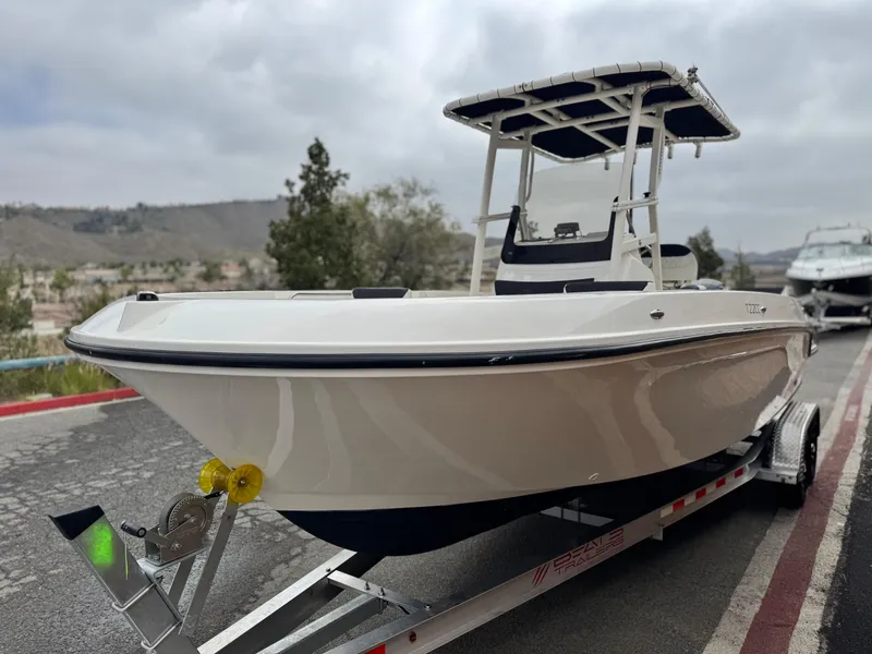Slide: The Image of 2022 Bayliner Trophy T22CC boat on trailer, parked on road with cloudy sky. - 3