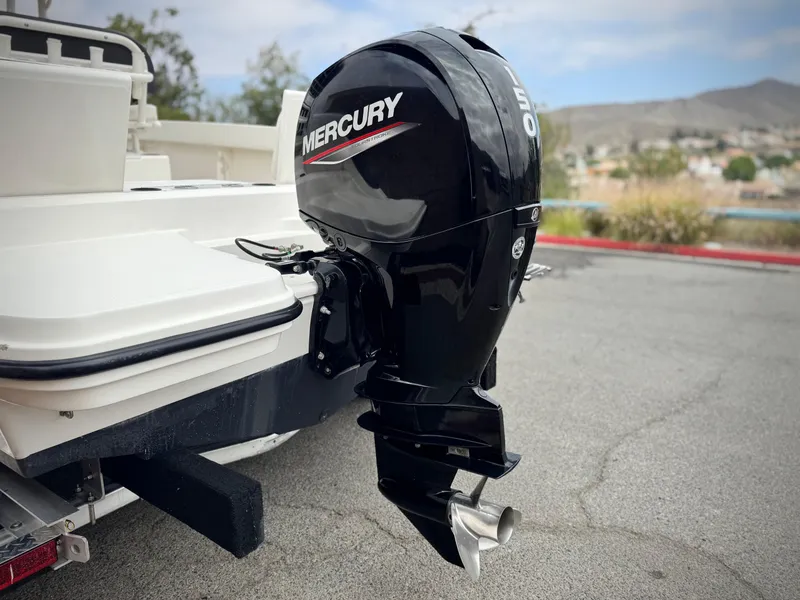 Slide: The Image of 2022 Bayliner Trophy T22CC with Mercury outboard motor, parked on pavement. - 6