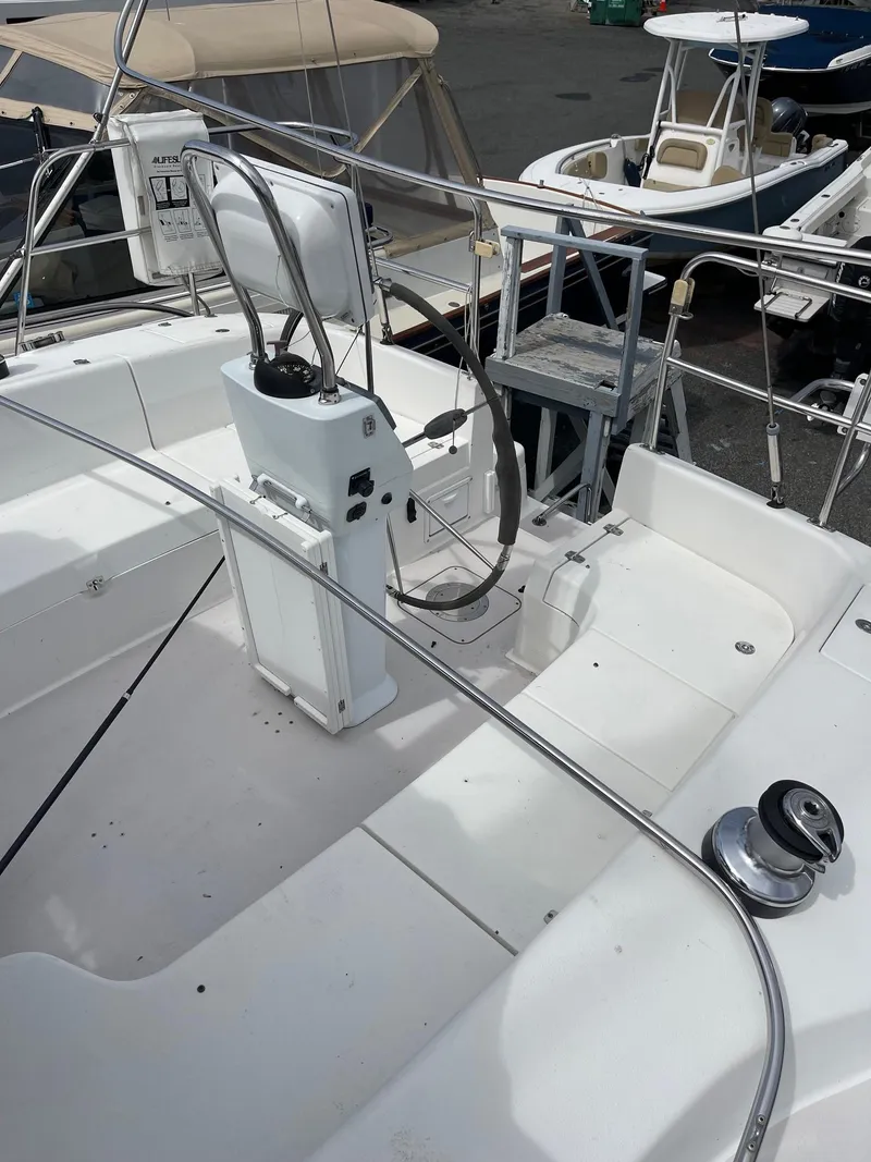 Slide: The Image of 2004 Catalina 350 sailboat cockpit with steering wheel and winch, docked at marina. - 3