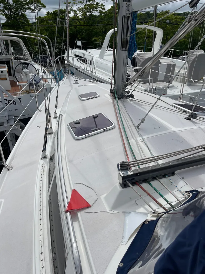 Slide: The Image of 2004 Catalina 350 sailboat deck with rigging and hatch, docked in a marina. - 5