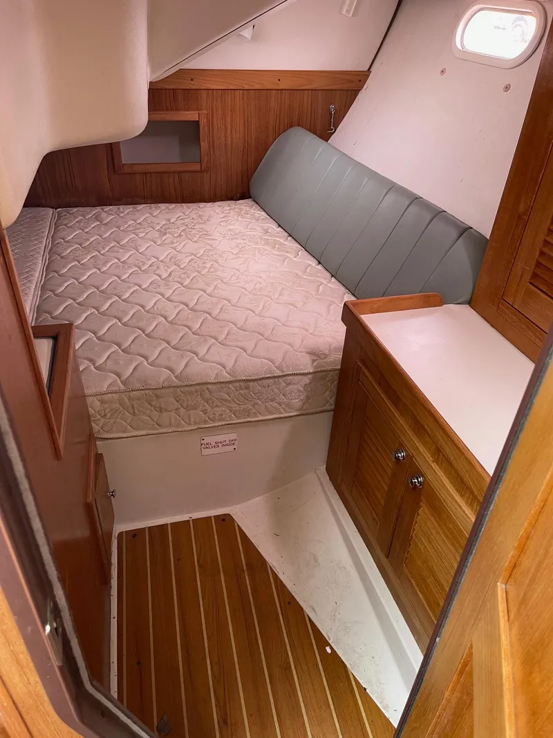 Slide: The Image of Interior cabin of a 2004 Catalina 350 sailboat with bed and wooden cabinetry. - 9