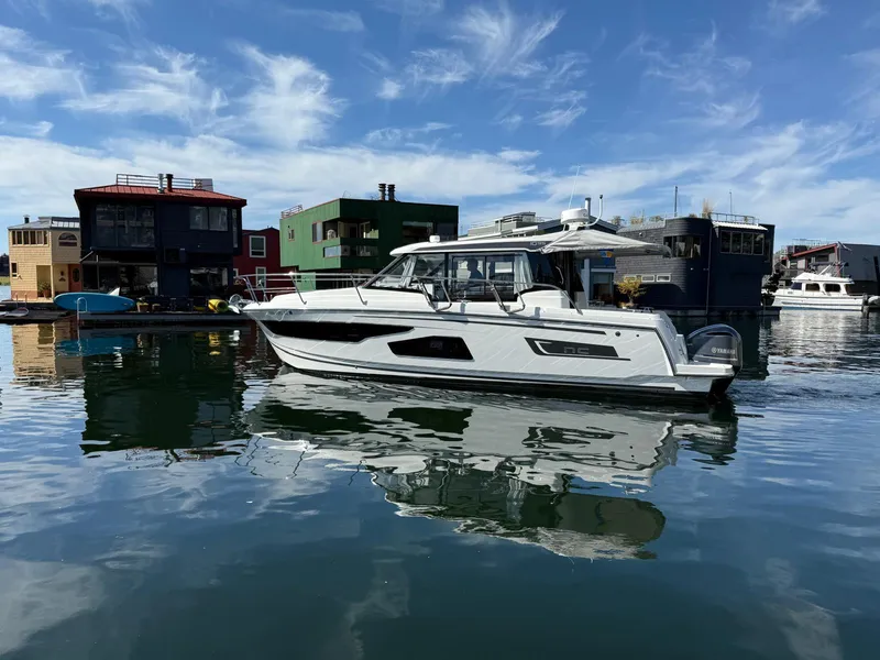 The Image of 2021 Jeanneau NC Weekender 1095 boat docked in a scenic marina setting. - 0