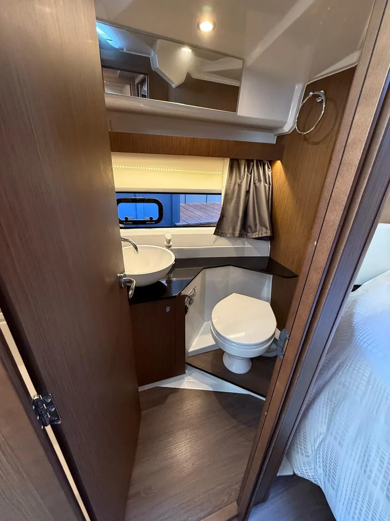 Slide: The Image of 2021 Jeanneau NC Weekender 1095 bathroom with sink, toilet, and window. - 11