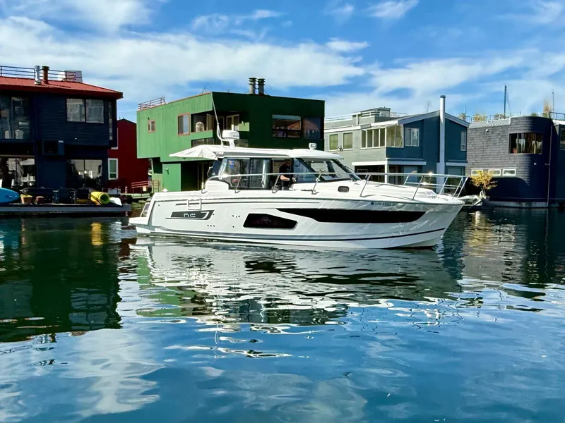Slide: The Image of 2021 Jeanneau NC Weekender 1095 boat docked near colorful waterfront houses. - 26