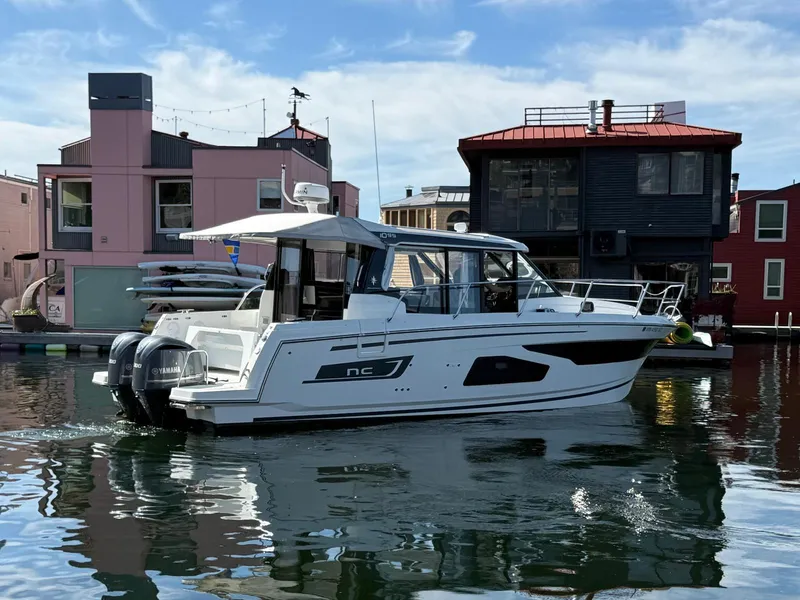 Slide: The Image of 2021 Jeanneau NC Weekender 1095 boat docked near colorful waterfront buildings. - 4