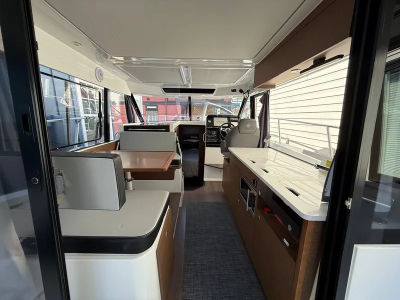Slide: The Image of Interior of 2021 Jeanneau NC Weekender 1095, featuring modern kitchen and seating area. - 7