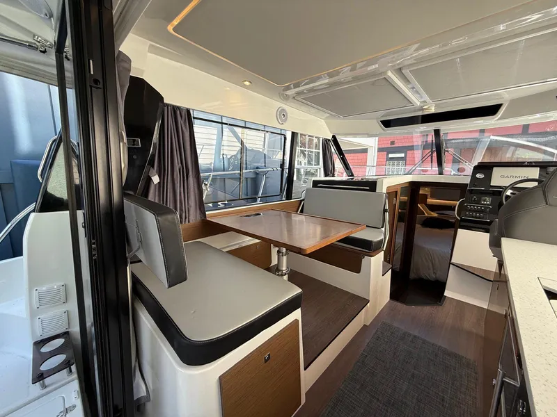 Slide: The Image of Interior of 2021 Jeanneau NC Weekender 1095, featuring dining area and helm station. - 9