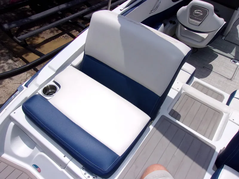 Slide: The Image of 2021 Crownline 210SS boat interior with blue and white seating and cup holder. - 15