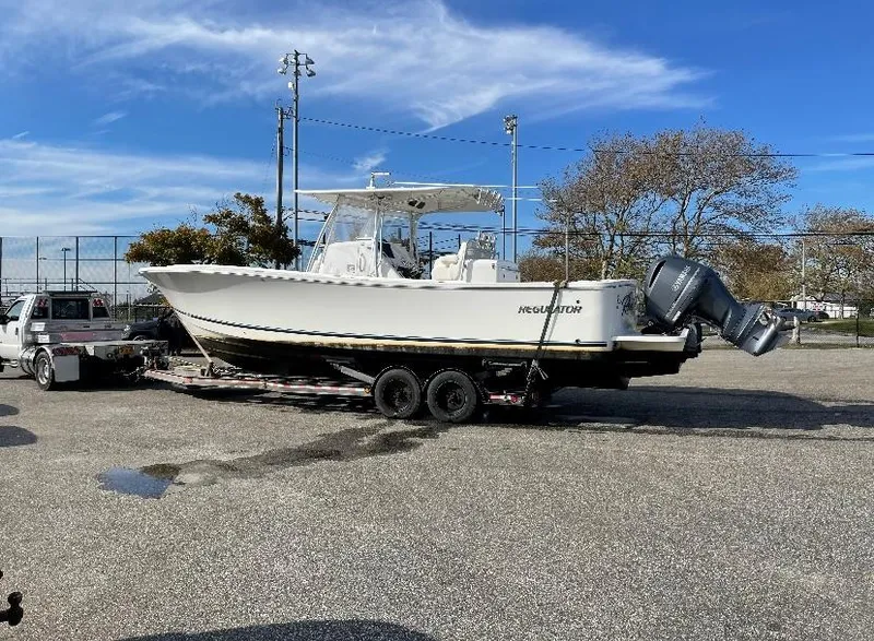 Slide: The Image of 2019 Regulator 31 FS boat on trailer, parked outdoors under a clear blue sky. - 11