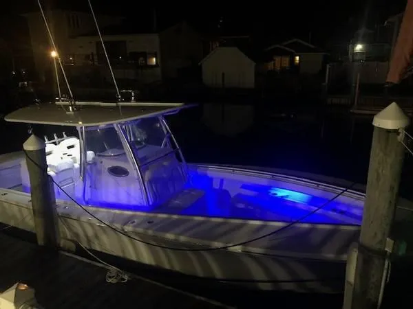 Slide: The Image of 2019 Regulator 31 FS boat docked at night with blue interior lights. - 13