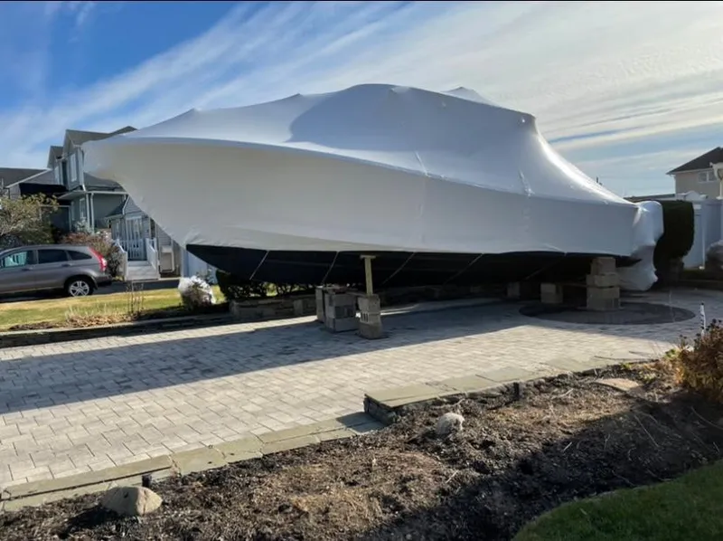Slide: The Image of 2019 Regulator 31 FS boat covered and elevated on blocks in a residential driveway. - 14