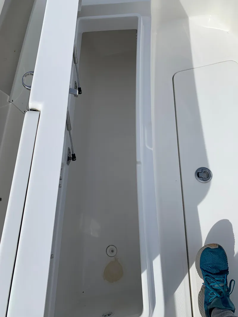 Slide: The Image of 2019 Regulator 31 FS boat interior with open storage compartment and visible foot. - 31