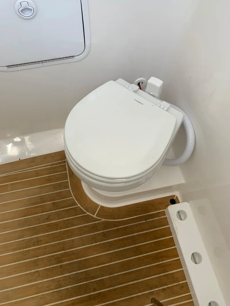 Slide: The Image of 2019 Regulator 31 FS boat bathroom with white toilet and wooden floor. - 34