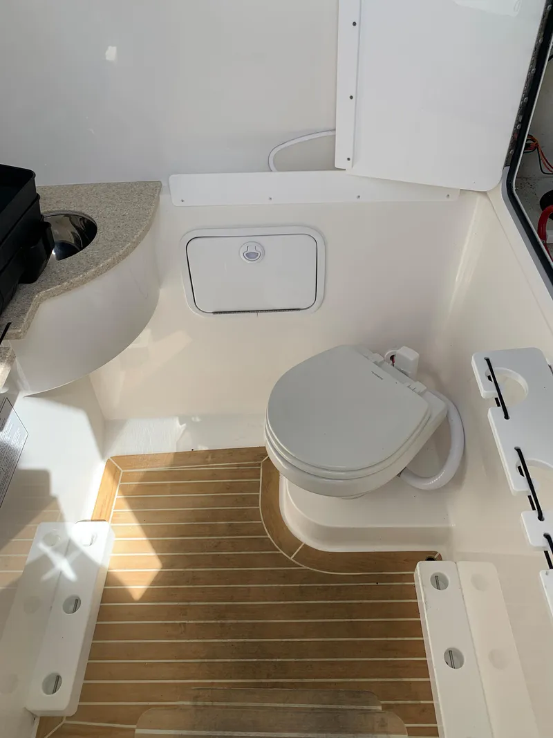 Slide: The Image of 2019 Regulator 31 FS boat interior with toilet and wooden flooring. - 35