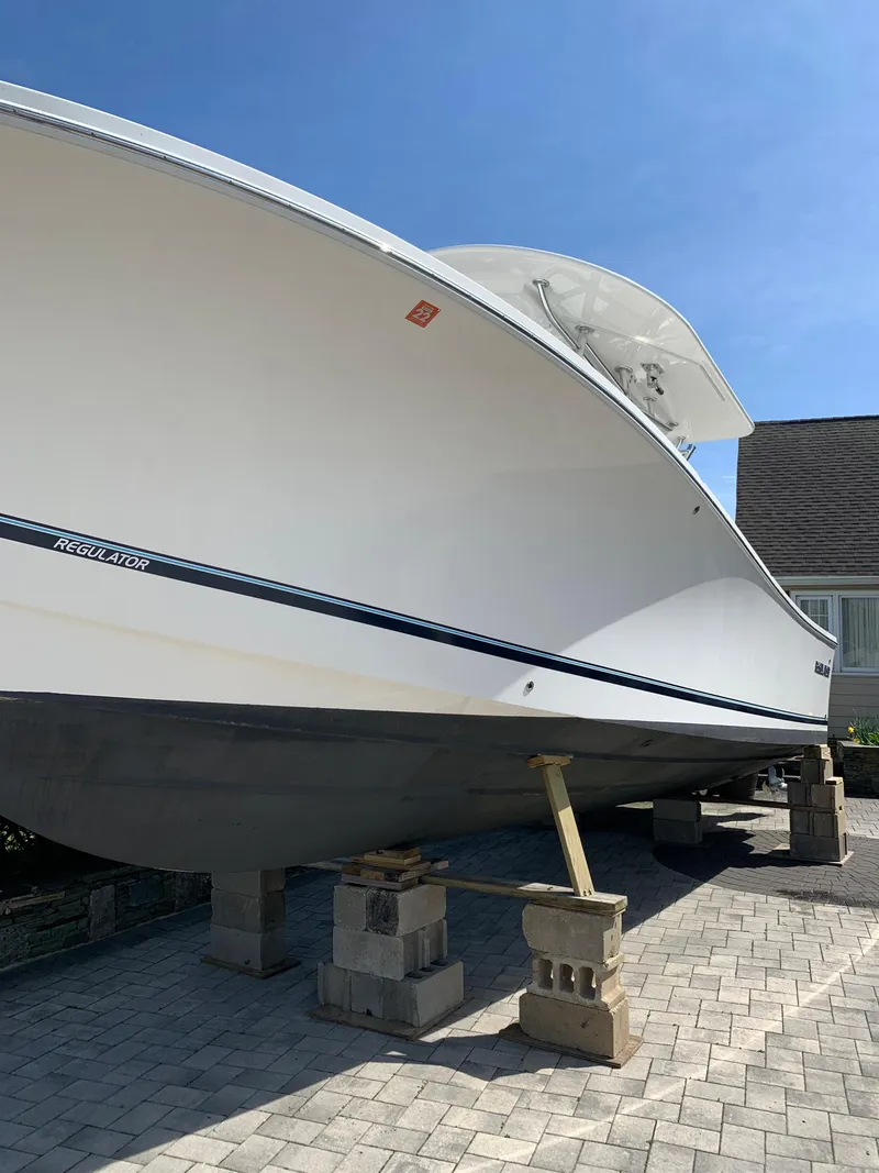 Slide: The Image of 2019 Regulator 31 FS boat on blocks, displayed outdoors on a sunny day. - 7
