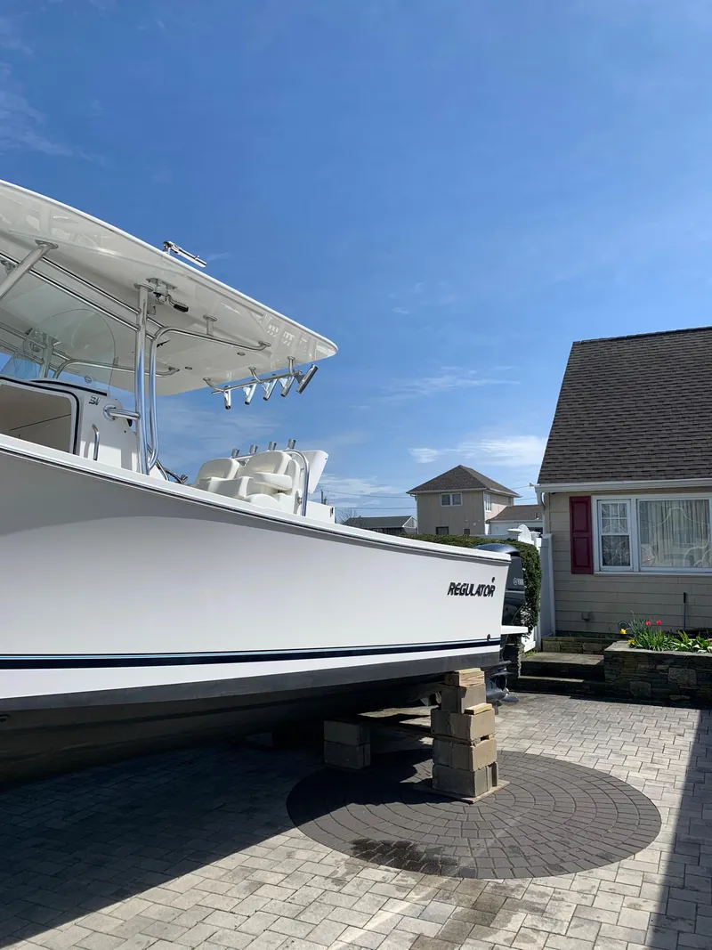 Slide: The Image of 2019 Regulator 31 FS boat on blocks in a driveway under a clear blue sky. - 9
