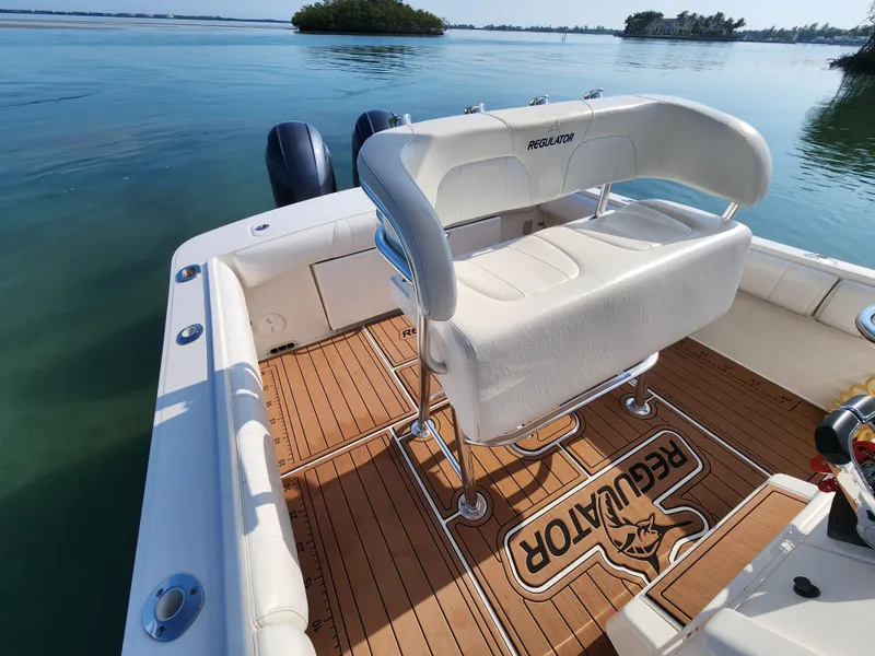 Slide: The Image of 2015 Regulator 25 boat with teak deck and seating, on calm water. - 13