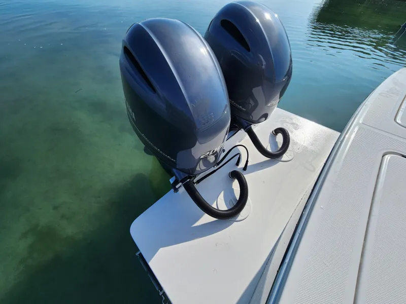 Slide: The Image of Twin outboard motors on a 2015 Regulator 25 boat in clear water. - 15