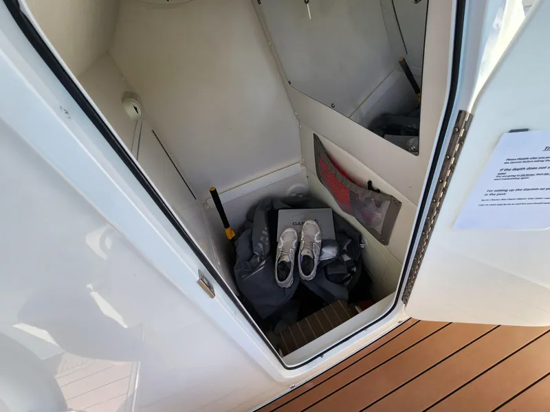 Slide: The Image of Storage compartment on 2015 Regulator 25 boat with shoes and gear. - 17
