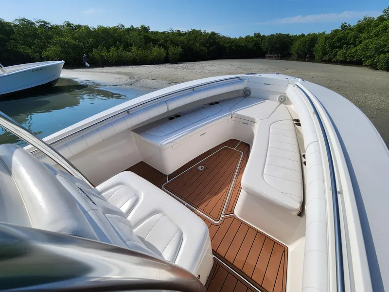 Slide: The Image of 2015 Regulator 25 boat with white seating and teak flooring, docked near mangroves. - 19