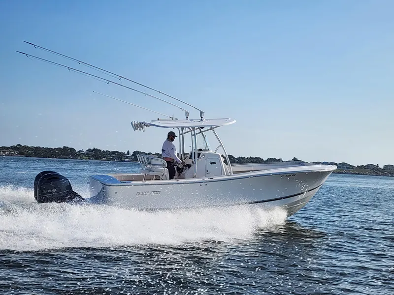 Slide: The Image of 2015 Regulator 25 boat cruising on open water under clear blue sky. - 23