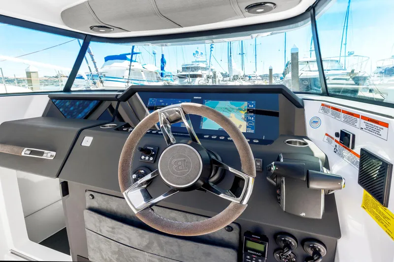 Slide: The Image of 2022 Axopar 37 Cross Cabin Brabus Trim dashboard with steering wheel and navigation display. - 16