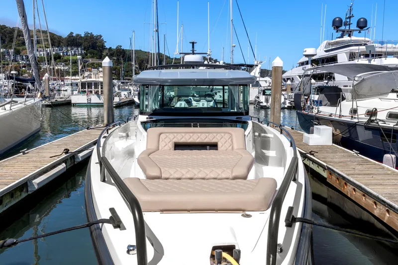Slide: The Image of 2022 Axopar 37 Cross Cabin Brabus Trim docked in a marina, featuring luxurious seating. - 2