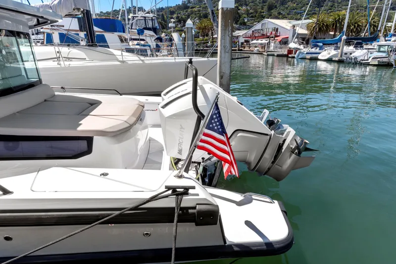Slide: The Image of 2022 Axopar 37 Cross Cabin Brabus Trim docked with American flag, marina background. - 24