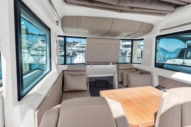 Slide: The Image of Interior of 2022 Axopar 37 Cross Cabin Brabus Trim, featuring luxurious seating and wooden table. - 37