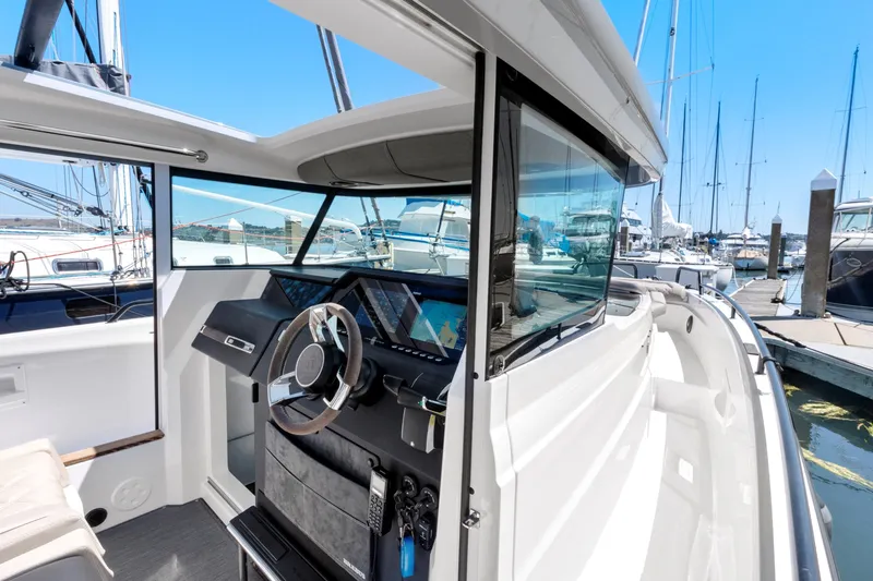 Slide: The Image of 2022 Axopar 37 Cross Cabin Brabus Trim boat interior with modern dashboard and steering wheel. - 38