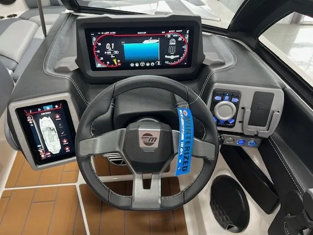 Slide: The Image of 2025 Malibu Wakesetter 24 MXZ dashboard with advanced digital controls and steering wheel. - 10