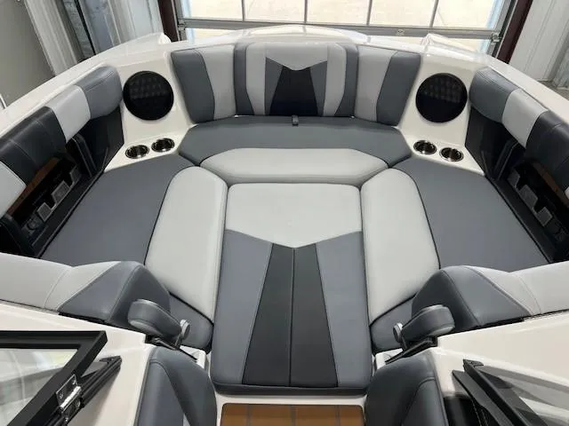 Slide: The Image of 2025 Malibu Wakesetter 24 MXZ interior with gray and black seating, cup holders, and speakers. - 11