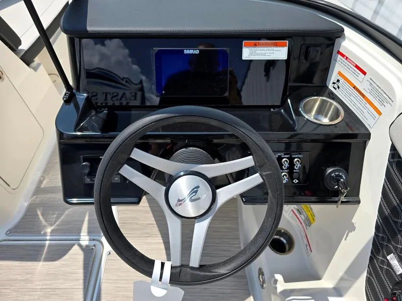 Slide: The Image of 2025 Sea Ray SPX 190 Simrad display, sst drinkholder, Fusion BT stereo with custom steering wheel and control panel. - 11