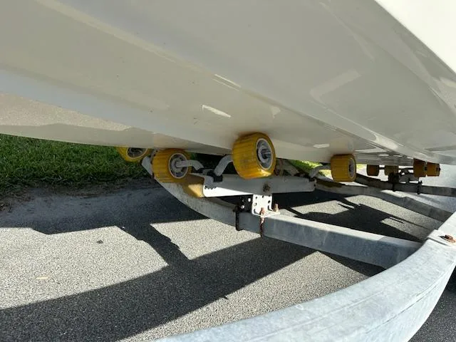 Slide: The Image of Bayliner 190 Bowrider 2013 on trailer with yellow rollers, parked on pavement. - 16