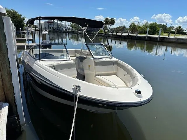 Slide: The Image of 2013 Bayliner 190 Bowrider docked on calm water under a clear blue sky. - 3