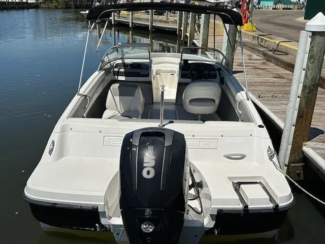 Slide: The Image of 2013 Bayliner 190 Bowrider boat docked, featuring a sleek design and outboard motor. - 4