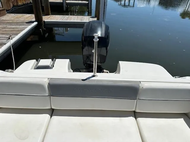 Slide: The Image of 2013 Bayliner 190 Bowrider boat with outboard motor, docked on calm water. - 5