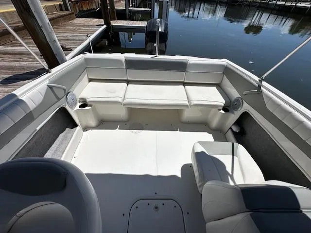 Slide: The Image of 2013 Bayliner 190 Bowrider interior with white seating, docked by the water. - 8