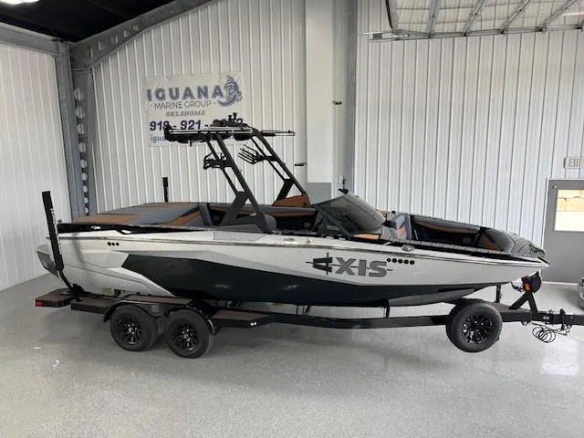 The Image of 2024 Axis A225 boat on trailer in showroom, featuring sleek design and modern features. - 1