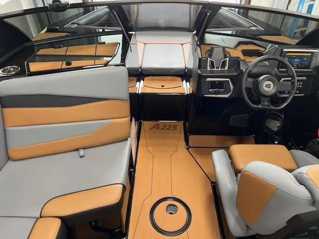 Slide: The Image of 2024 Axis A225 boat interior with modern design, featuring tan and gray seating and advanced dashboard. - 15