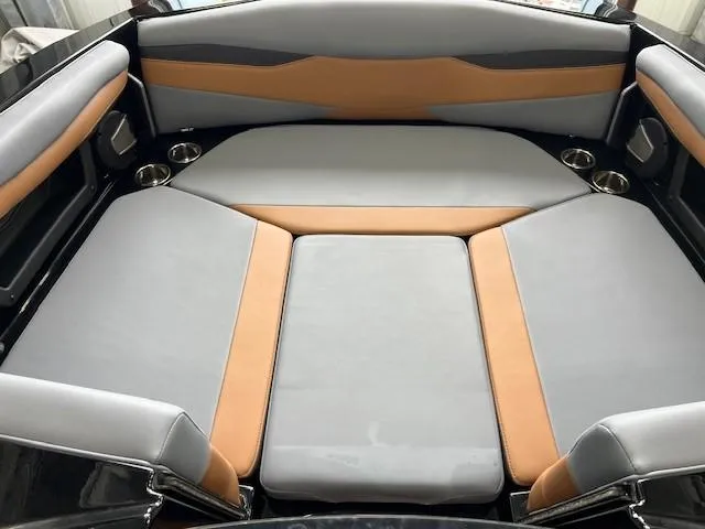 Slide: The Image of 2024 Axis A225 boat interior with gray and tan seating, cup holders, and modern design. - 16