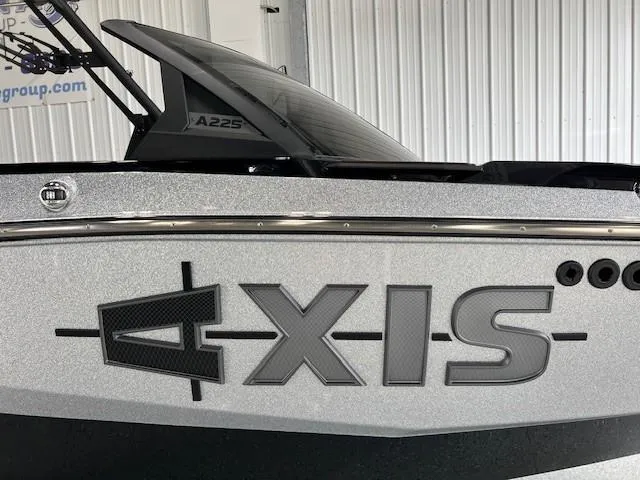 Slide: The Image of 2024 Axis A225 boat with sleek design and bold logo in a showroom. - 4