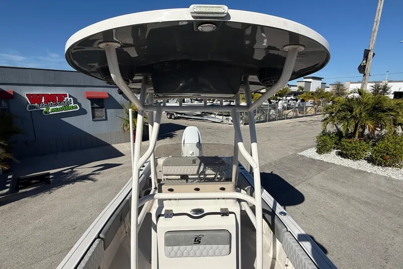Slide: The Image of 2025 Carolina Skiff 21 Ultra Elite boat with T-top, parked at a dealership. - 23