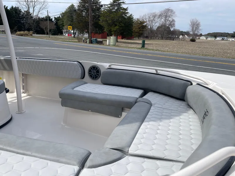 Slide: The Image of 2025 Carolina Skiff 21 Ultra Elite boat with outboard motor, parked outdoors. - 6